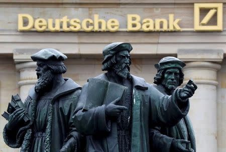 A statue is pictured next to the logo of Germany's Deutsche Bank in Frankfurt, Germany September 30, 2016. REUTERS/Kai Pfaffenbach/File Photo