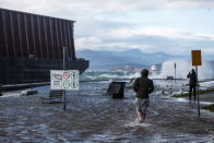 <p>A pedestrian walks along a flooded sea wall past a barge that came loose from its mooring after rainstorms lashed the western Canadian province of British Columbia in Vancouver, British Columbia, Canada November 15, 2021. REUTERS/Jesse Winter</p> 