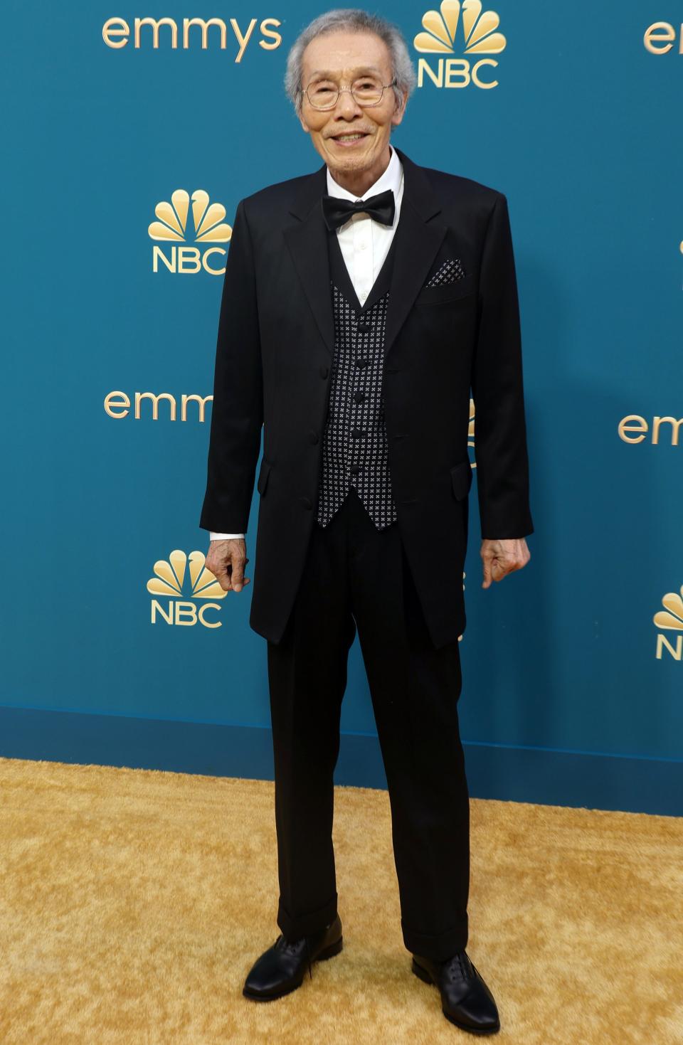 Oh Yeong-soo smiling and wearing a tux by a step and repeat