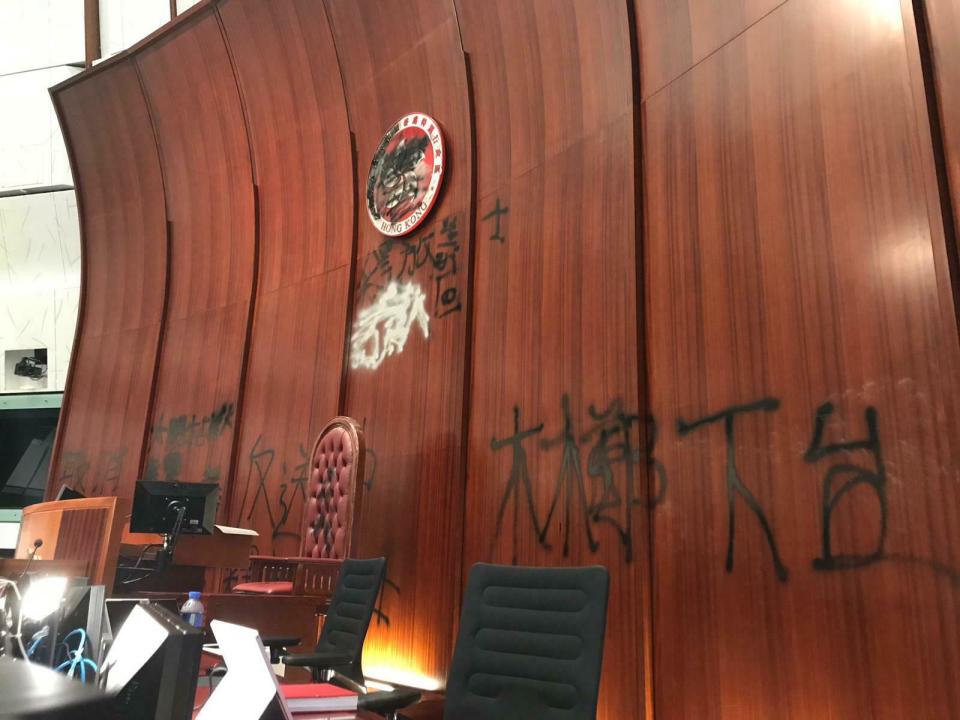 Damage to the Legislative Council following a break-in by protesters is seen during a media tour, Wednesday, July 3, 2019, in Hong Kong. Characters read "Step down Carrie Lam." (AP Photo/Johnson Lai)