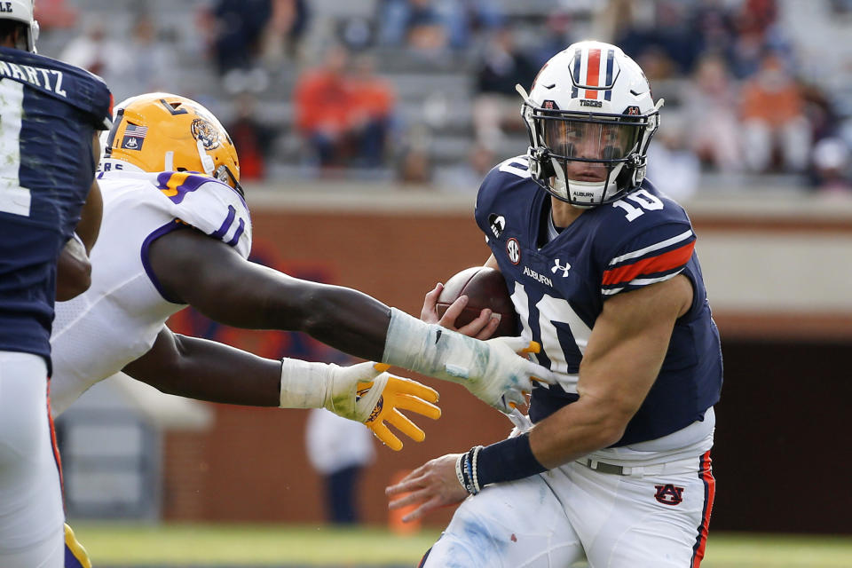 Auburn quarterback Bo Nix (10) eludes a tackle by LSU defensive lineman Ali Gaye (11) as he carries the ball during the second quarter of an NCAA college football game Saturday, Oct. 31, 2020, in Auburn, Ala. (AP Photo/Butch Dill)