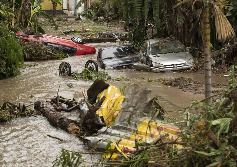 Vehicles that were carried away in flash floods after heavy rains lay in a creek in the Realengo neighborhood of Rio de Janeiro, Brazil, Monday, March 2, 2020. The water flooded the streets and entered homes of residents, with at least 4 deaths reported. (AP Photo/Silvia Izquierdo)