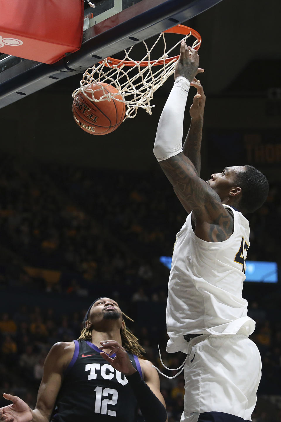 West Virginia forward Jimmy Bell Jr. (43) scores over TCU forward Xavier Cork (12) during the second half of an NCAA college basketball game Wednesday, Jan. 18, 2023, in Morgantown, W.Va. (AP Photo/Kathleen Batten)