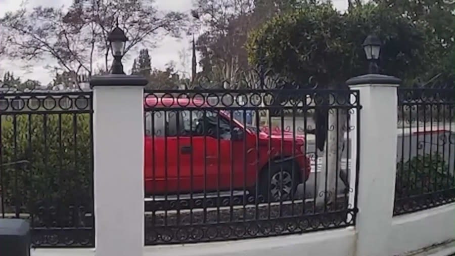 The suspect smashing the windshield of a red pickup truck in Tarzana on March 29, 2024.