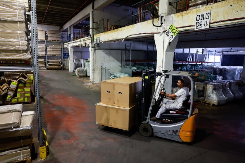A member of staff from Hollandia International uses a forklift in the company warehouse facility that was struck and damaged by a rocket that was launched from the Gaza Strip into Sderot