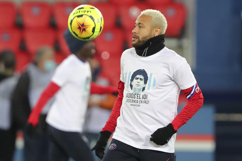 El brasileño Neymar, del París Saint-Germain, porta una camiseta con la imagen de de Diego Maradona, durante un calentamiento previo al partido de la liga francesa ante Burdeos, el sábado 28 de noviembre de 2020 (AP Foto/Thibault Camus)