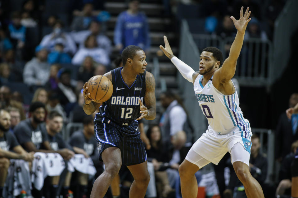 Orlando Magic forward Gary Clark, left, looks to pass around Charlotte Hornets forward Miles Bridges in the first half of an NBA basketball game in Charlotte, N.C., Monday, Jan. 20, 2020. (AP Photo/Nell Redmond)