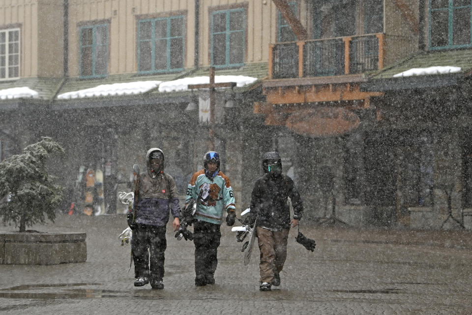 Snow falls as skiers walk along The Village at Northstar Resort on their way to the lifts on Thursday, Feb. 29, 2024, in Truckee, Calif. The most powerful Pacific storm of the season started barreling into the Sierra Nevada on Thursday, packing multiple feet of snow and dangerous winds that forecasters say will create blizzard conditions likely to close major highways and trigger power outages into the weekend.(AP Photo/Andy Barron)