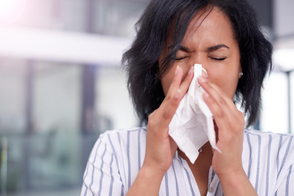 Cropped shot of a businesswoman working in her office while suffering from allergies