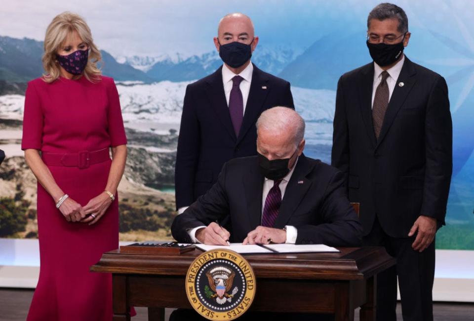 Joe Biden signs an executive order as Jill Biden looks on