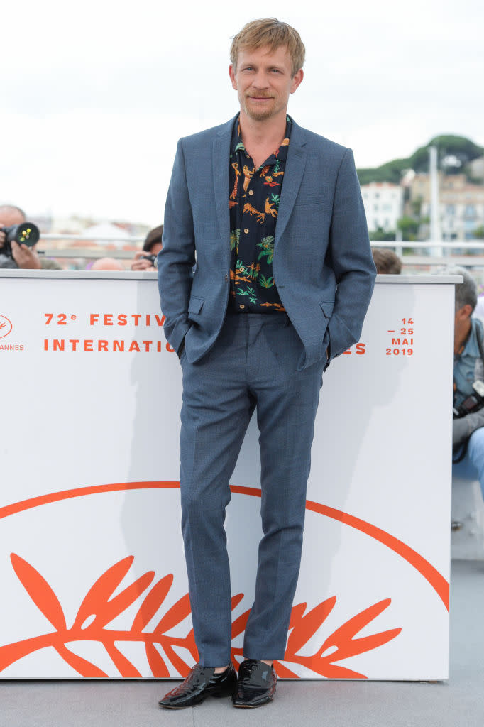 Jéremie Renier s’est amusé à casser les codes lors du photocall de Frankie. Si l’acteur portait un très sérieux costume, il l’a twisté avec une chemise aux motifs exotiques et a volontairement oublié de mettre des chaussettes dans ses chaussures vernies. Une audace qui paie !