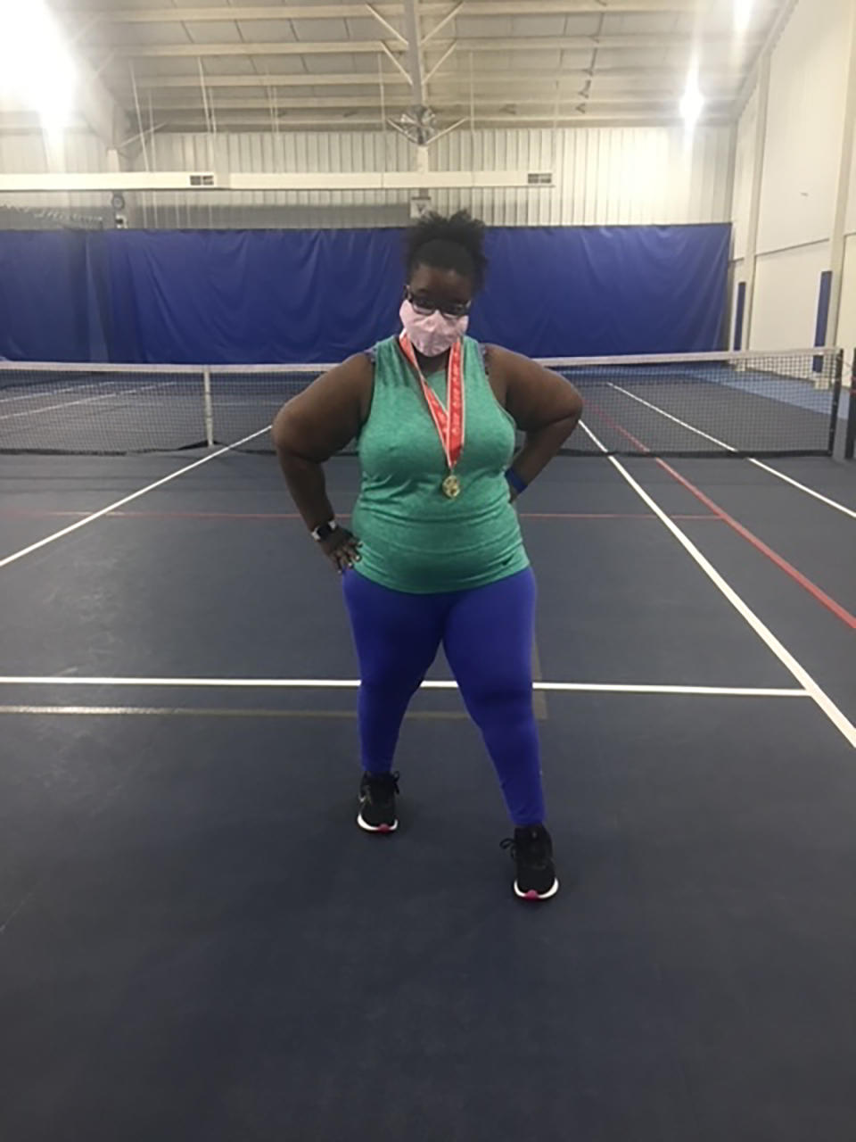 Ruqayyah Cherie Bailey pauses for a photo to celebrate taking first place in the beginners' tennis division of the Missouri Special Olympics on Oct. 3, 2020, in Jefferson City, Mo. The 31-year-old autistic St. Louis County resident was barely making enough as a part-time cafe cashier. When COVID-19 hit, the cafe closed, she lost her job and moved home with her mom. By any measure, Ruqayyah Bailey has had a tough year, but she is focused on her accomplishments, not her challenges. "I did it! I did it! I worked hard and I did it!" she said when asked what the photo means to her. (Pat Hawkins via AP)