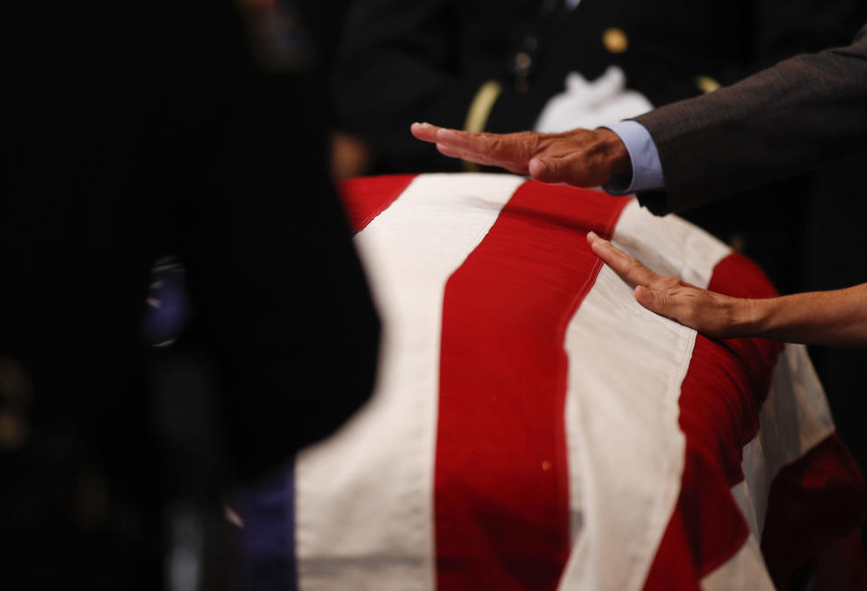 Mourners touch the casket during the memorial service. (Photo: JAE C. HONG / Getty Images)