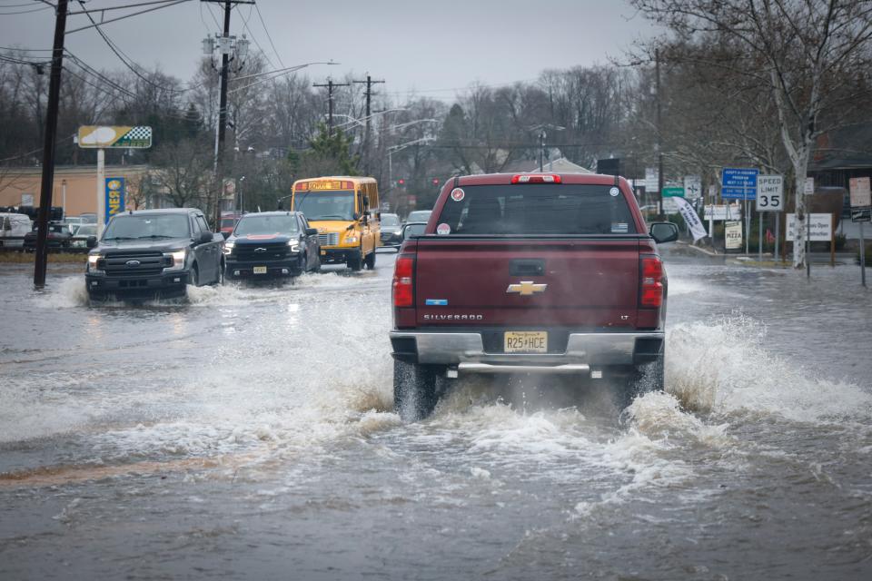 Cars drive through a flooded street in New Jersey after a large rainstorm (Getty Images)