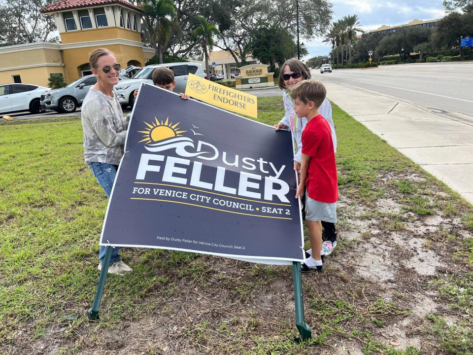 Dusty Feller, left, Mitzie Fiedler and two of Feller’s triplets attempt to prop up one of Feller's campaign signs in the 700 block of Tamiami Trail South on the island of Venice. The metal support stakes were both bent over near the ground.