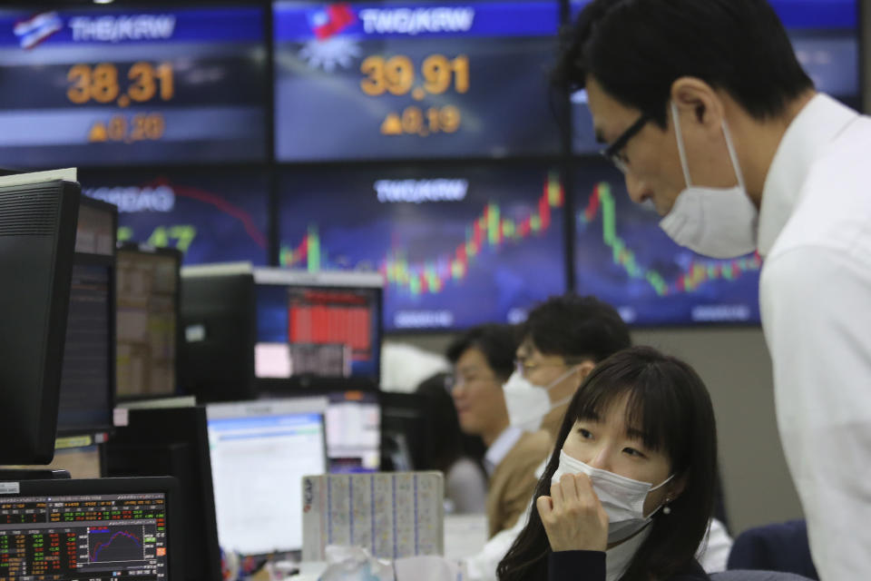 Currency traders watch monitors at the foreign exchange dealing room of the KEB Hana Bank headquarters in Seoul, South Korea, Wednesday, Feb. 26, 2020. Asian shares slid Wednesday following another sharp fall on Wall Street as fears spread that the growing virus outbreak will put the brakes on the global economy.(AP Photo/Ahn Young-joon)