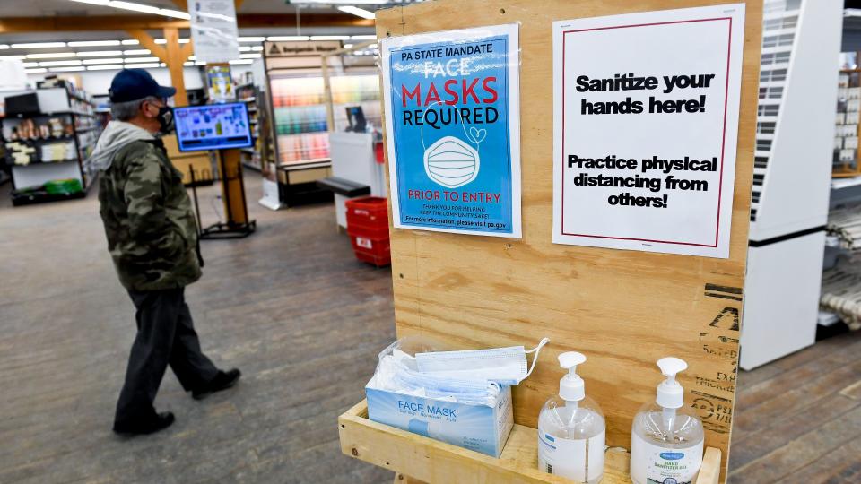 Hand sanitizer and face masks on a wooden shelf