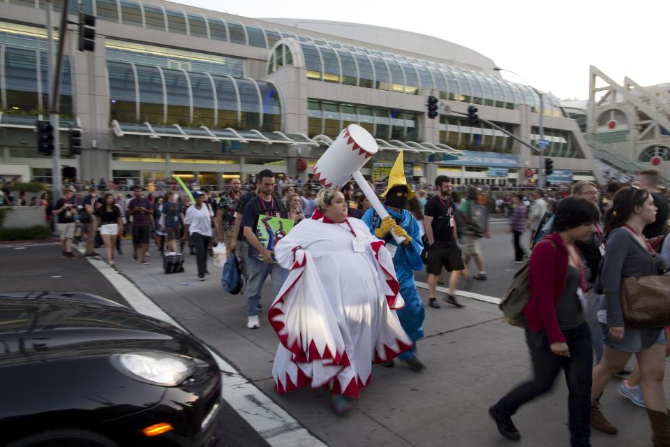 People cross the street during Comic-Con Thursday, July 24, 2014, in San Diego. Thousands of fans with four-day passes to the sold-out pop-culture spectacular flocked to the event Thursday, many clad in costumes. (AP Photo)