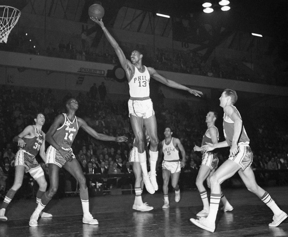 FILE - Wilt Chamberlain, of the Philadelphia Warriors, center, stretches for a basket against the Los Angeles Lakers at the Philadelphia Arena in Philadelphia on Feb. 28, 1961. (AP Photo/Warren M. Winterbottom, File)