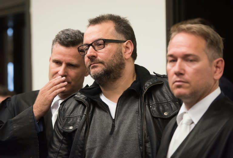 Defendant Wilfried Wagener (C) stands next to his lawyers Detlev Binder (L) and Carsten Ernst (R) in the courtroom of the regional court in Paderborn, northern Germnay, on October 26, 2016 ahead of the trial against him and his ex-wife