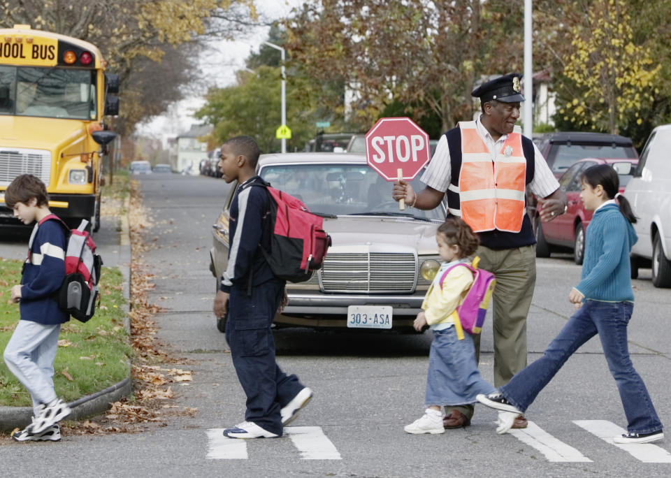 Lollipop man helps kids cross the road. Source: Getty Images