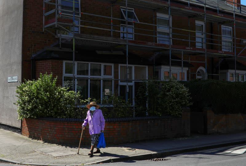 A woman wears a protective face mask as she walks in the Lozells area of Birmingham