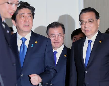 Chinese Premier Li Keqiang, Japanese Prime Minister Shinzo Abe and South Korean President Moon Jae-in walk together to their summit in Tokyo, Wednesday, May 9, 2018. Eugene Hoshiko/Pool via Reuters