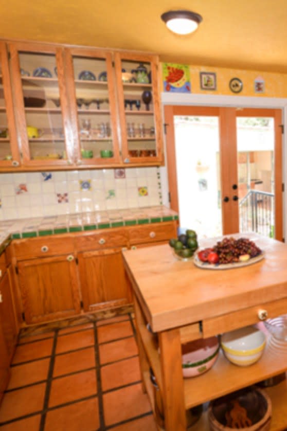 BEFORE: The kitchen in this house was once a complete ’90s throwback, thanks to terra-cotta tiles, color-matched cabinetry, and bright yellow walls.