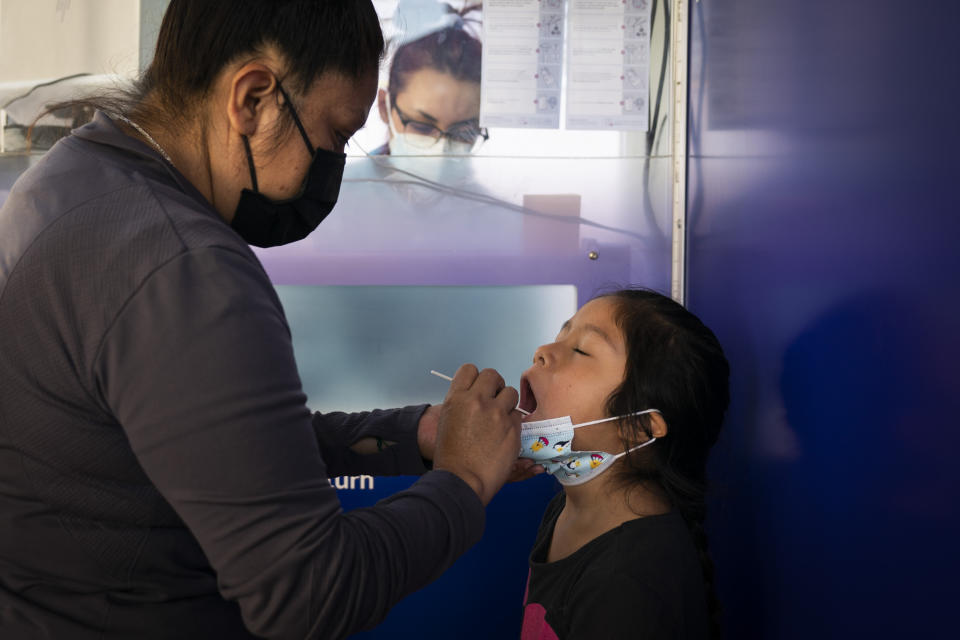 Claudia Campos swabs the mouth of her daughter, Katie Ramirez, at a testing site in Los Angeles on Dec. 9, 2020.  (Photo: AP Photo/Jae C. Hong)
