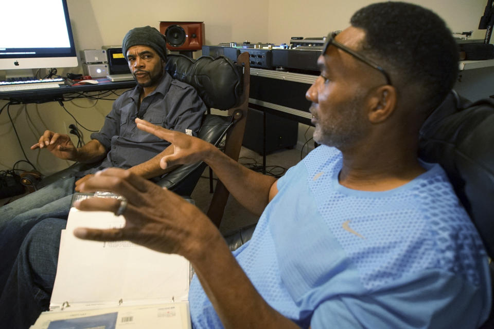 Musician Youtha Anthony Fowler, known as DJ Nabs, left, listens to lifelong best friend Alton Lucas talk about his drug addiction in Nabs' home studio outside of Raleigh, N.C., on Saturday, June 26, 2021. By their teenage years, Lucas and Fowler were deejaying for college parties at nearby Duke University. Together, “Luke Duke,” as Lucas was known, and “Nabisco Disco,” as Fowler was called, helped popularize hip-hop music among undergraduates. (AP Photo/Allen G. Breed)