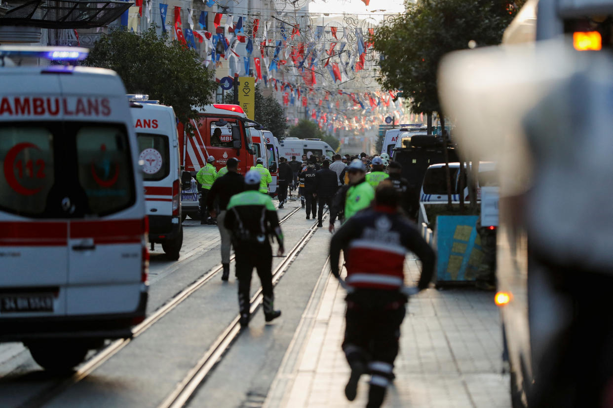 Police and emergency service members work at the scene after an explosion on busy pedestrian Istiklal street in Istanbul.