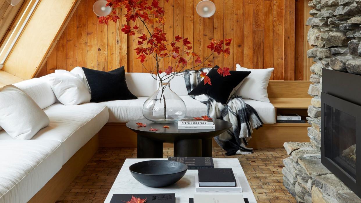  Living room with wood panelling on walls and white corner sofa. 