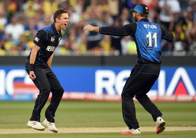 New Zealand's Trent Boult (L) is congratulated by teammate Daniel Vettori after dismissing Australia's Aaron Finch during their Cricket World Cup final in Melbourne on March 29, 2015