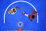 Los Angeles Lakers' LeBron James, left, goes up for a dunk against Philadelphia 76ers' Joel Embiid during the first half of an NBA basketball game, Friday, Dec. 9, 2022, in Philadelphia. (AP Photo/Matt Slocum)