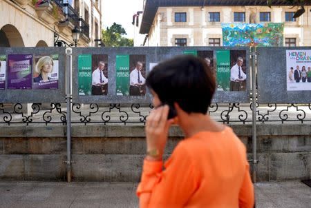 A woman walks past election posters for Basque nationalist Party (PNV) candidate, Inigo Urkullu, in the Basque town of Guernica, northern Spain, September 21, 2016. REUTERS/Vincent West