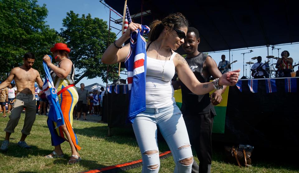 Bibi Perdormo of Quincy, Mass., dances with Femi Omoniyi of Providence as the live music starts up at the 44th Cape Verdean Independence Day Festival, in 2019 at India Point Park.