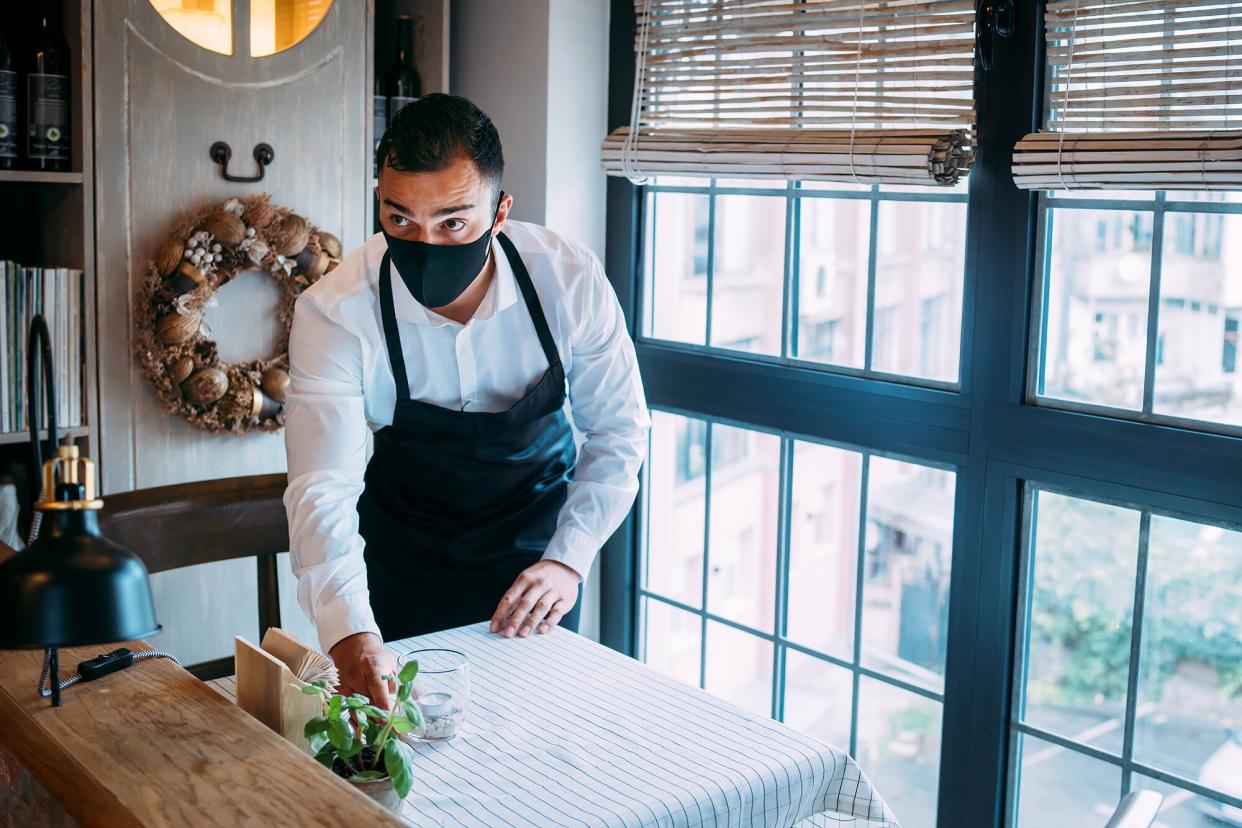 A server sets the table at a fine-dining establishment