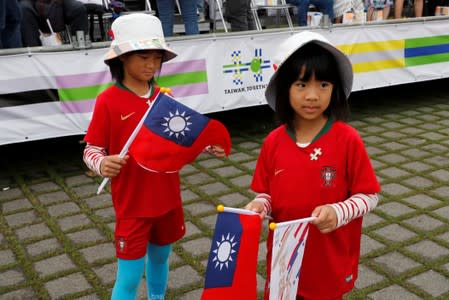 Twin girls hold Taiwanese flags before the National Day celebrations in Taipei