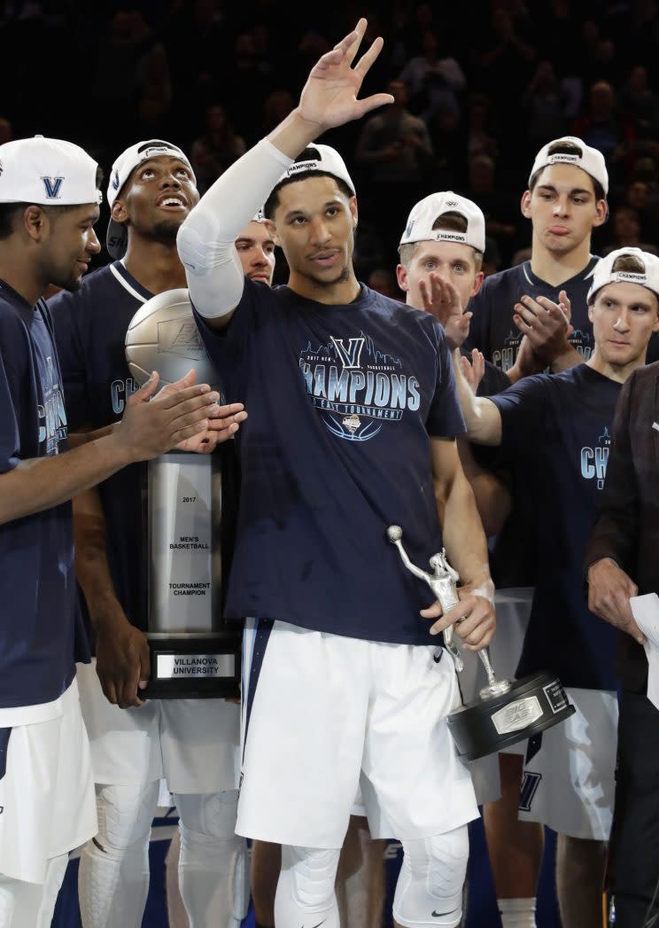 Villanova’s Josh Hart, center, gestures to the crowd while holding the Most Outstanding Player trophy and posing for photographs with his teammates after a championship NCAA college basketball game against Creighton in the finals of the Big East men’s tournament Saturday, March 11, 2017, in New York. Villanova won 74-60. (AP Photo/Frank Franklin II)