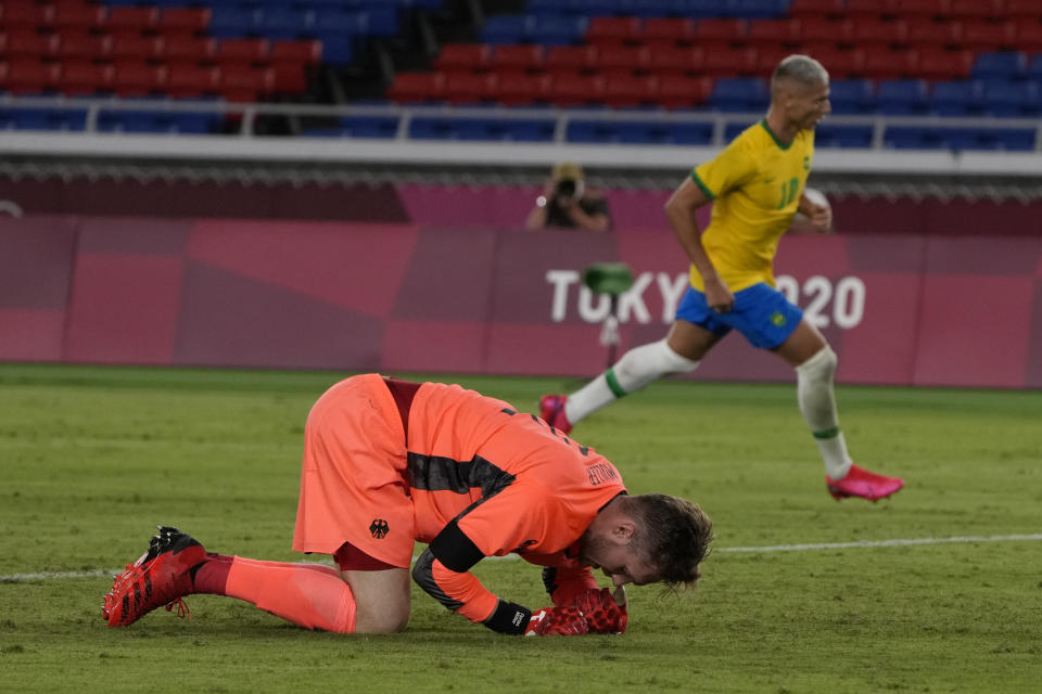 Germany's goalkeeper Florian Mueller kneels after Brazil's Richarlison sacred his side's third goal during a men's soccer match at the 2020 Summer Olympics, Thursday, July 22, 2021, in Yokohama, Japan. (AP Photo/Kiichiro Sato)