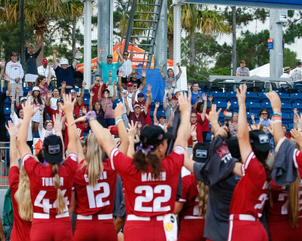 Arkansas Razorbacks players Abby Gordon (No. 12), Linni Malkin (No. 22), and Callie Turner (No. 44) call the hogs with fans and teammates after winning the game against the Missouri Tigers and capturing the SEC Softball Tournament at Katie Seashole Pressly Stadium at the University of Florida in Gainesville, Florida, on Saturday, May 14, 2022.