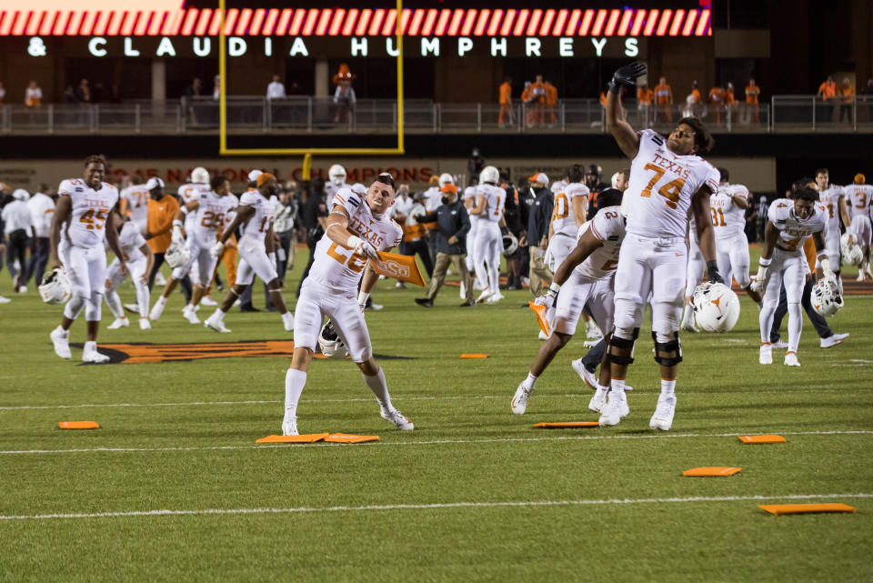 Oct 31, 2020; Stillwater, Oklahoma, USA;  Texas Longhorns defensive back Christian Tschauner (26) throws a seat cushion as offensive lineman Rafiti Ghirmai (74) celebrates after defeating the Oklahoma State Cowboys in overtime at Boone Pickens Stadium. Mandatory Credit: Texas won 41-34. Brett Rojo-USA TODAY Sports