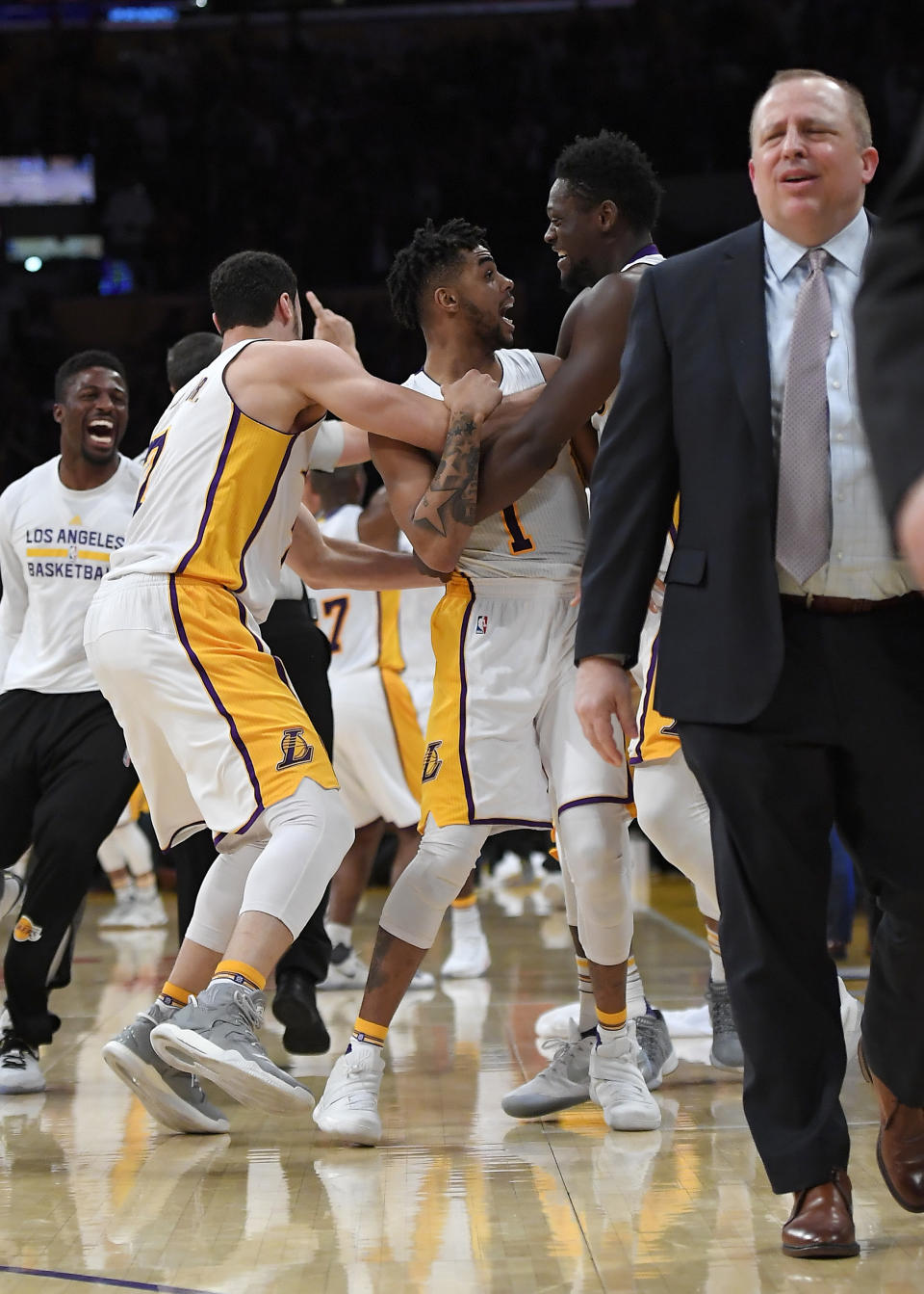 Los Angeles Lakers guard D'Angelo Russell (1) celebrates with teammates after hitting a game-winning three point shot as Minnesota Timberwolves head coach Tom Thibodeau walks off the court during the second half of an NBA basketball game, Sunday, April 9, 2017, in Los Angeles. The Lakers won 110-109. (AP Photo/Mark J. Terrill)