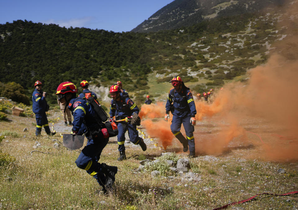 Firefighters of the 1st Wildfire Special Operation Unit, take part in a drill near Villia village some 60 kilometers (37 miles) northwest of Athens, Greece, Friday, April 19, 2024. Greece's fire season officially starts on May 1 but dozens of fires have already been put out over the past month after temperatures began hitting 30 degrees Celsius (86 degrees Fahrenheit) in late March. This year, Greece is doubling the number of firefighters in specialized units to some 1,300, adopting tactics from the United States to try and outflank fires with airborne units scrambled to build breaks in the predicted path of the flames. (AP Photo/Thanassis Stavrakis)