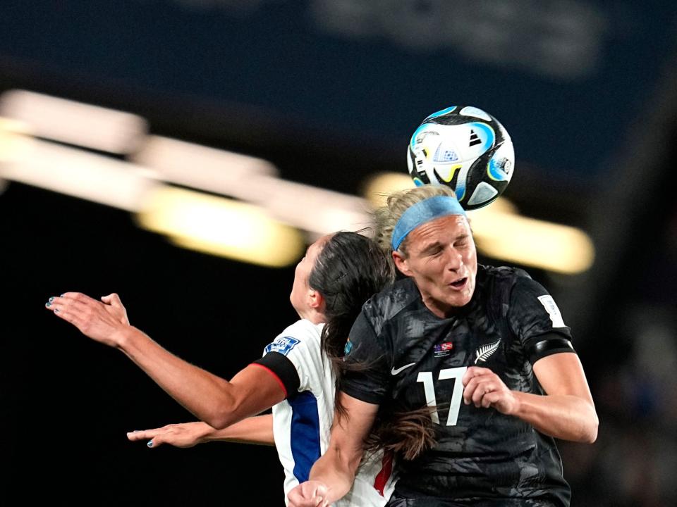 Hannah Wilkinson closing her eyes while jumping for a header with Ingrid Syrstad Engen as a ball fall near their heads.