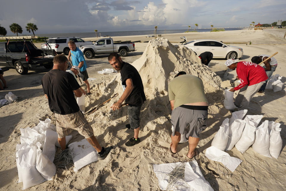 Local residents fill sand bags as they prepare for the expected arrival of Hurricane Ida Saturday, Aug. 28, 2021, in Gulfport, Miss. (AP Photo/Steve Helber)