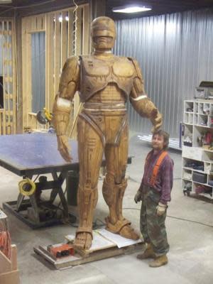 A sculptor stands with RoboCop statue (photo: Across the Board Creations)