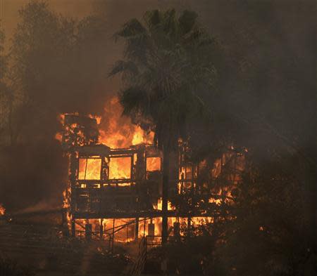 A fast-moving California wildfire, so-called the "Colby Fire," burns nearby homes, in the hills of Glendora January 16, 2014. REUTERS/Gene Blevins