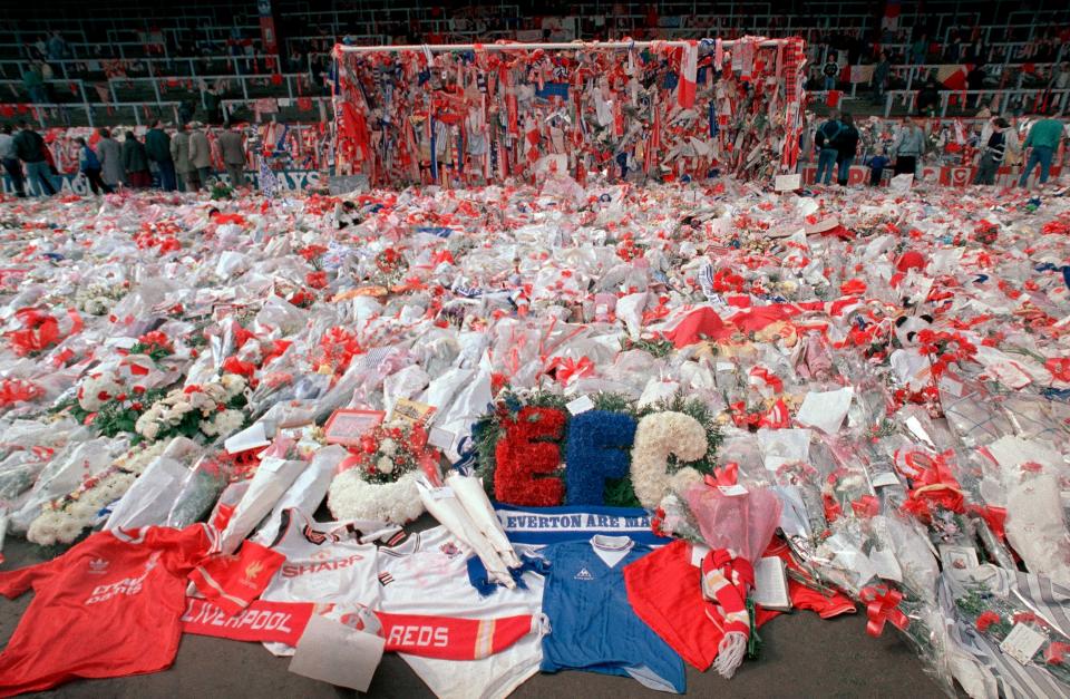 <p>Flower tributes cover the ‘Kop’ at Anfield in Liverpool, on 17 April 1989</p> (PA)