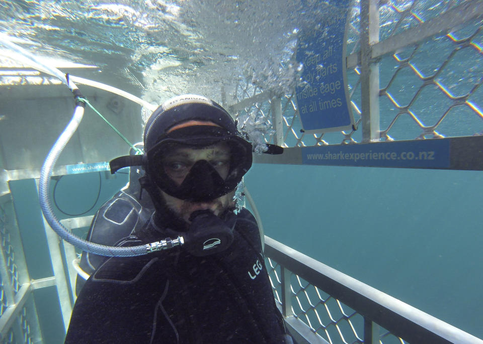 In this Jan 14, 2020, photo, Al Noor mosque shooting survivor waits in a shark cage to see great white sharks off the coast of Bluff in southern New Zealand. When the gunman walked into the mosque, Atacocugu was kneeling for Friday prayers. He looked up into the man's face, thinking he was a police officer because of his paramilitary outfit. Time slowed. Temel saw a puff of smoke come from the raised gun, felt a bullet smash into his teeth, and thought: "Oh, my God, I'm dying." (Temel Atacocugu via AP)